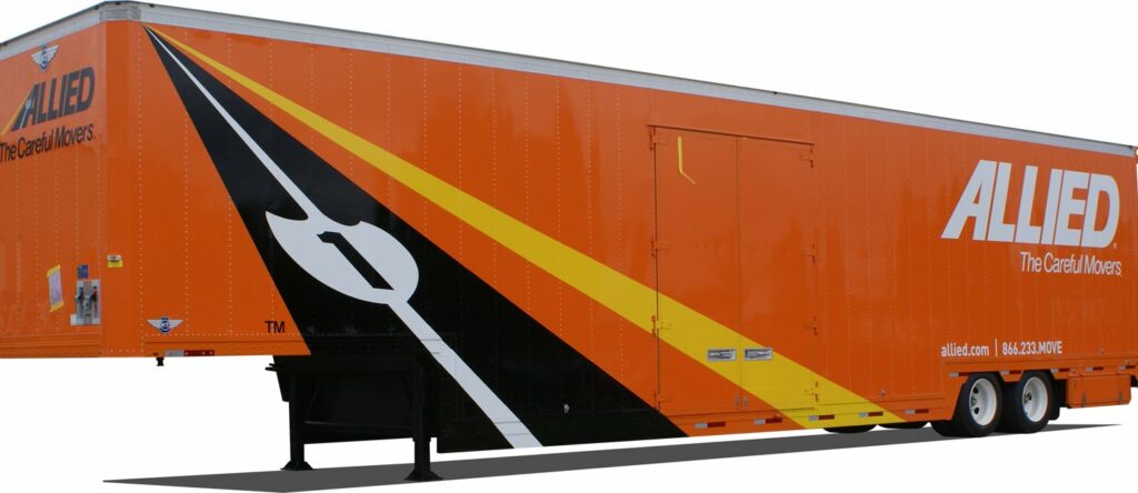 large orange double drop electronic trailer with yellow and black stripes